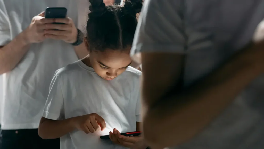 Child showing signs of phone addiction with anxious expression while holding smartphone, illustrating compulsive checking behavior